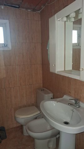 Cozy bathroom in a village property located in Seron, Almeria, featuring a toilet, sink, and mirror.