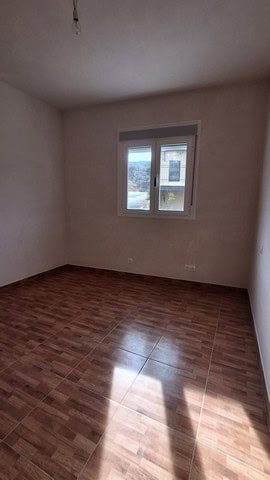 Interior view of a spacious, empty room with a window overlooking the countryside.
