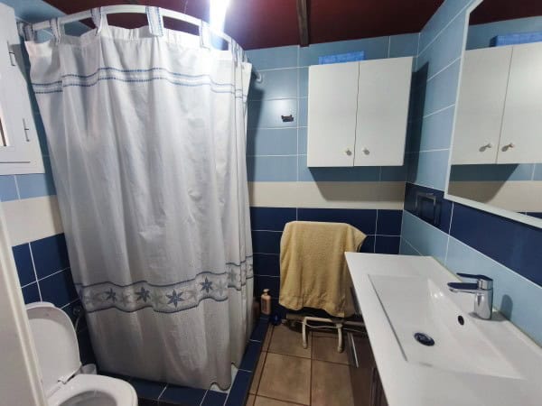 Charming bathroom in rural Quesada property with modern fixtures and blue tiled walls.