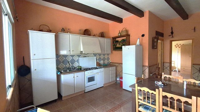 Country kitchen with white cabinets and tiled backsplash in Purchena, Almeria.