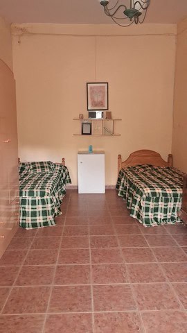 Simple rural bedroom with two single beds and minimal decor in Purchena, Almeria.