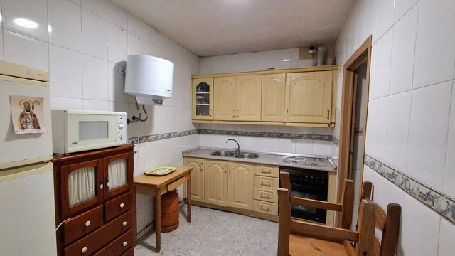 Spacious kitchen in a traditional village property in Urracal, Almeria, featuring wooden cabinets an.