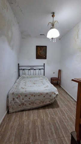 Cozy bedroom in village property in Urracal, Almeria with simple furnishings.