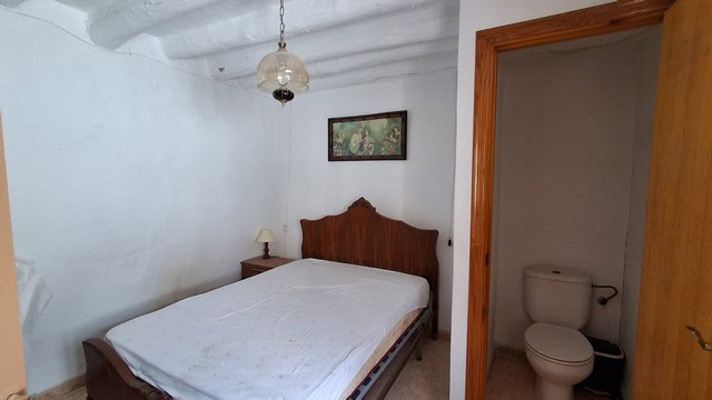 Charming village house interior in Urracal, Almeria, featuring a cozy bedroom with traditional decor.