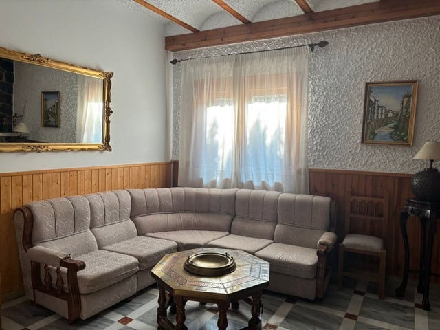 Spacious living room with a large L-shaped sofa, wooden accents, and natural light in a villa in Cul.