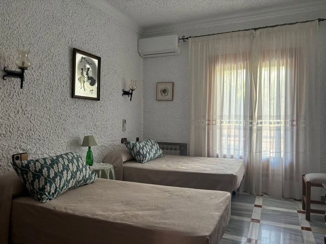 Cozy bedroom in a villa located in Cullar, Granada, featuring two single beds, decorative pillows, a.