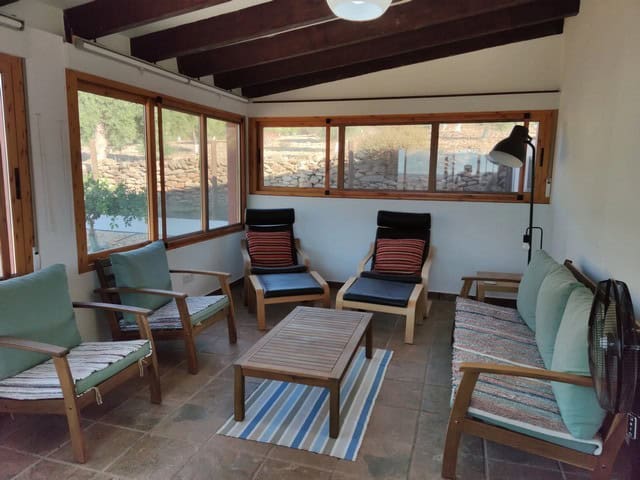 Cozy living room with large windows and wooden beams in Uleila del Campo villa, Almeria.
