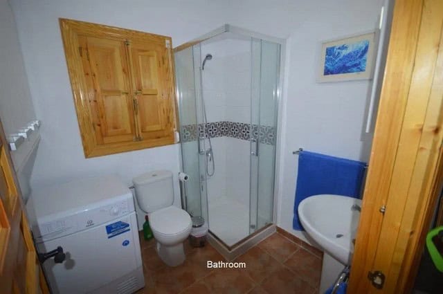 Compact bathroom with shower, toilet, and washing machine in Uleila del Campo, Almeria.