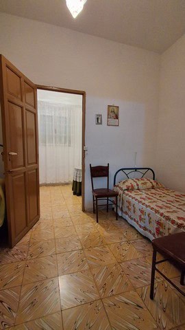 Charming town house bedroom in Seron, Almeria with wooden wardrobe, single bed, and simple decor.