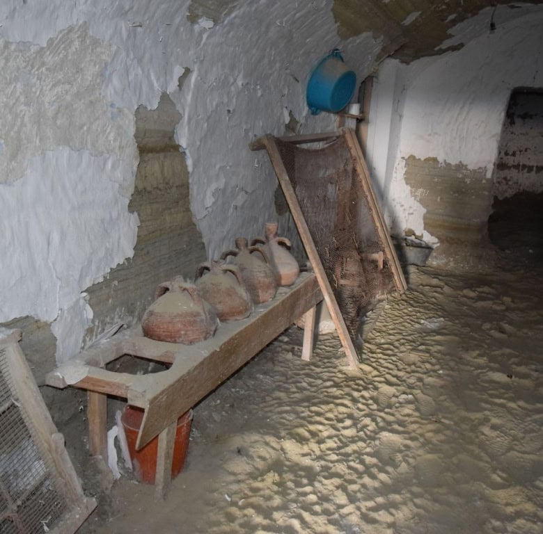Cave house interior in Benamaurel, Granada with rustic pottery and traditional decor.