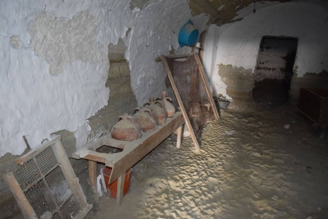 Cave house interior in Benamaurel, Granada with rustic pottery and traditional decor.