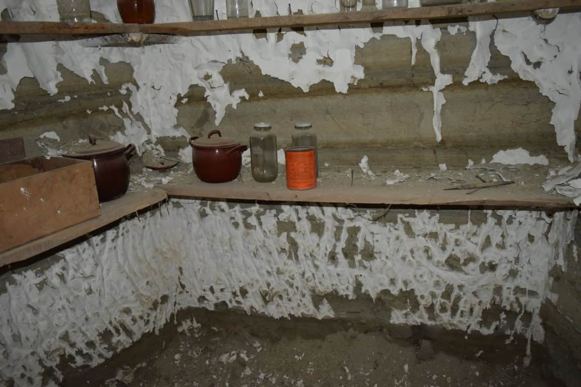 Interior view of a cave house in Benamaurel, Granada, showing rustic walls and simple storage.