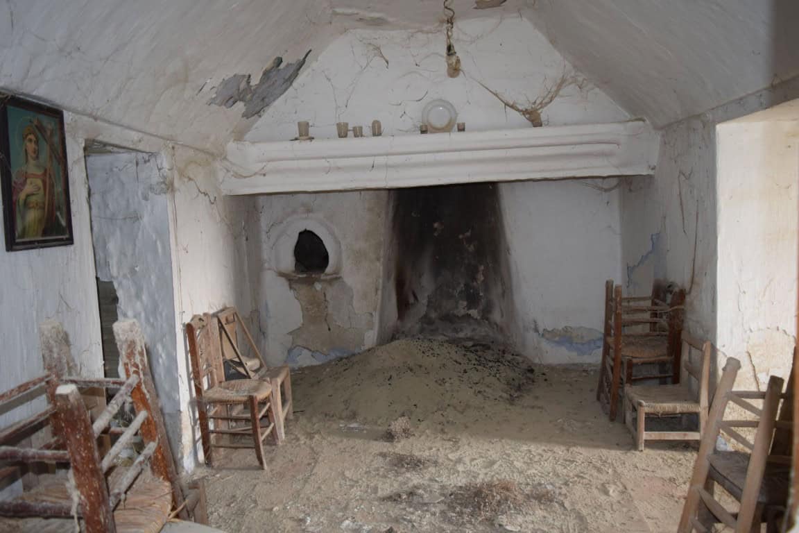 Unique cave house interior in Benamaurel, Granada, featuring rustic wooden chairs and a traditional.