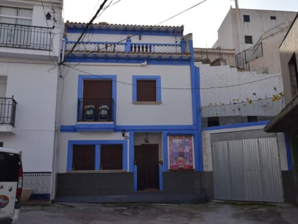 Cave house in Freila, Granada with traditional architecture and vibrant blue accents.