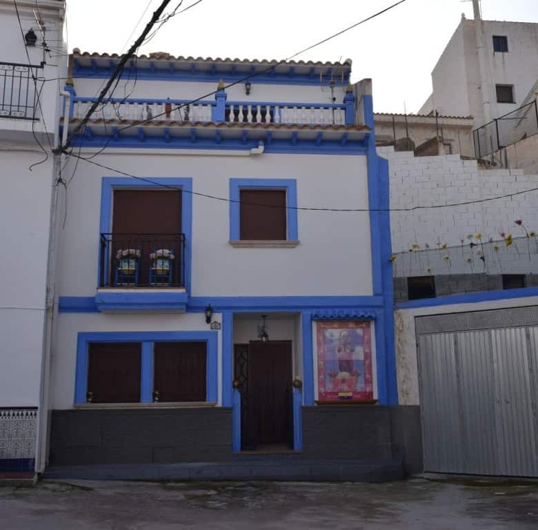 Cave house in Freila, Granada with traditional architecture and vibrant blue accents.