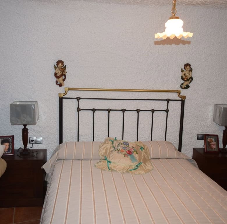 Cave house interior in Freila, Granada, featuring a cozy bedroom with vintage decor.
