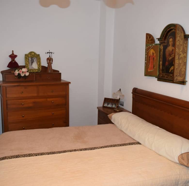 Charming cave house interior in Freila, Granada, featuring traditional decor and religious artwork.