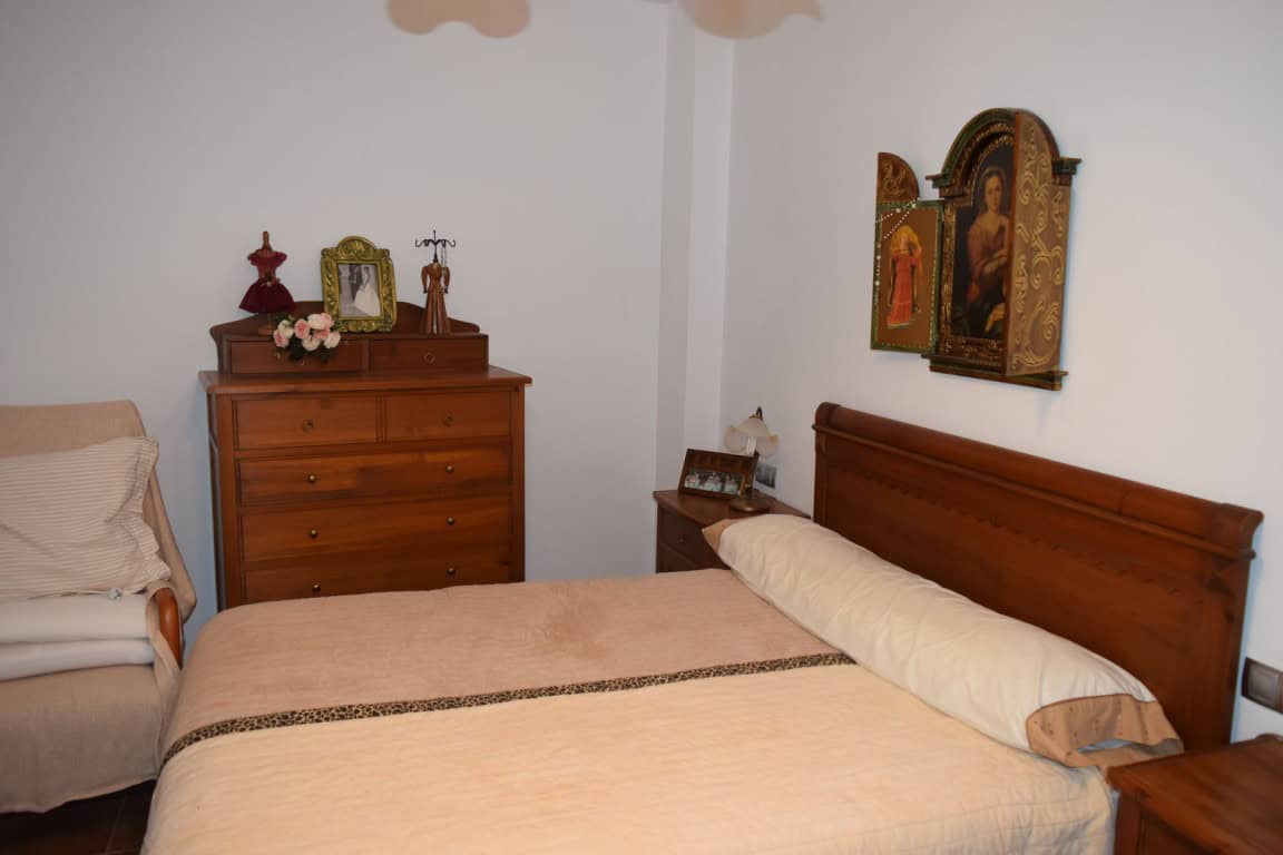 Charming cave house interior in Freila, Granada, featuring traditional decor and religious artwork.