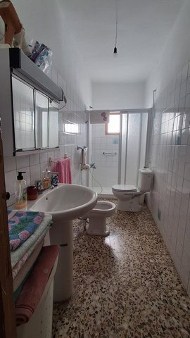 Bathroom of a town house in Seron, Almeria with white tiles and basic fixtures.