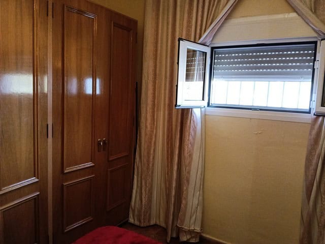 Rural property in Benamaurel with traditional wooden wardrobe and open window showing outdoor view.
