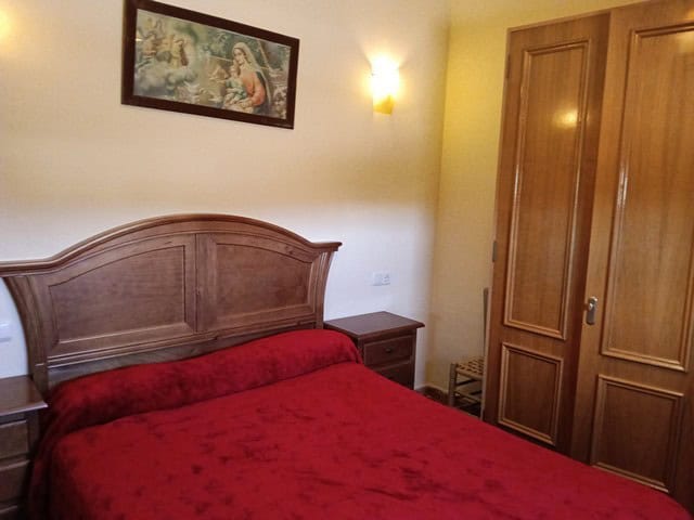 Charming bedroom in rural property located in Benamaurel, Granada, featuring a wooden bed and wardro.
