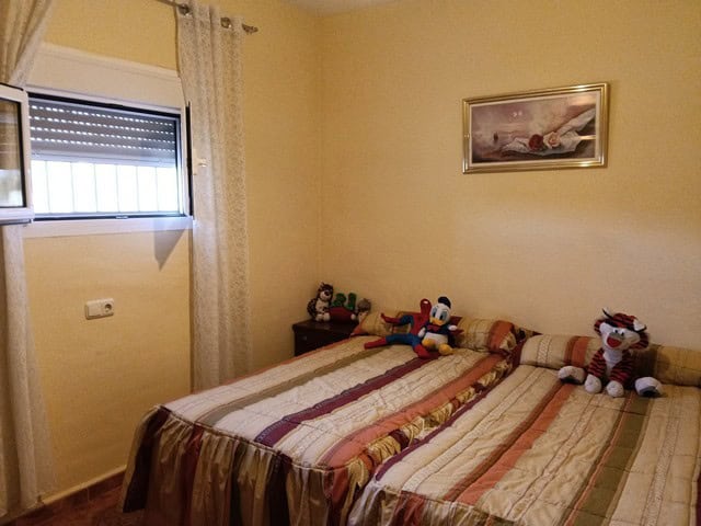Charming bedroom in rural Benamaurel, Granada, featuring cozy decor and plush toys.