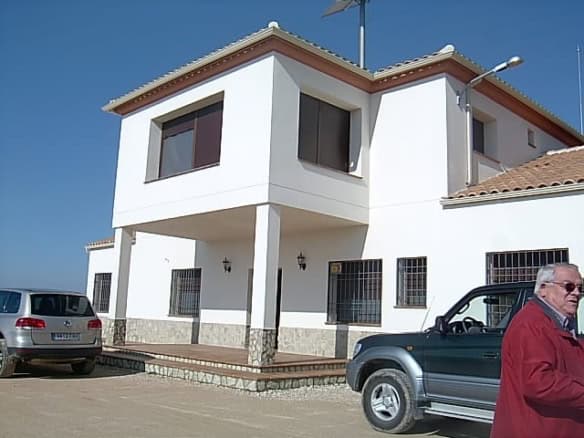 Finca in Huescar with modern white exterior and spacious balcony, set in scenic Granada countryside.
