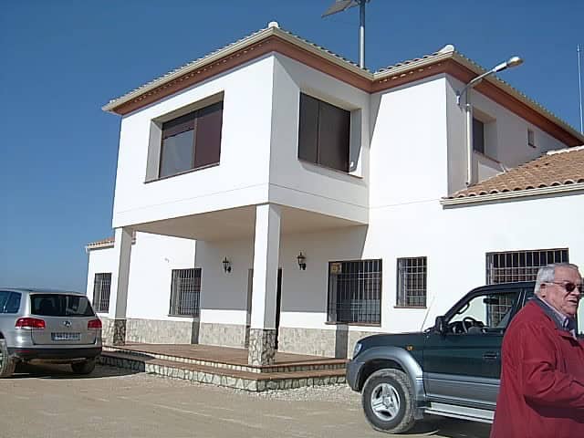 Finca in Huescar with modern white exterior and spacious balcony, set in scenic Granada countryside.