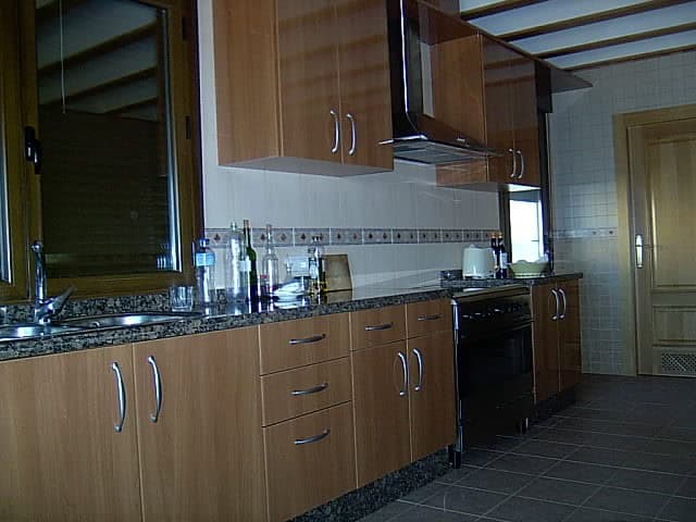 Cozy kitchen in a traditional finca located in Huescar, Granada, featuring wooden cabinets and moder.