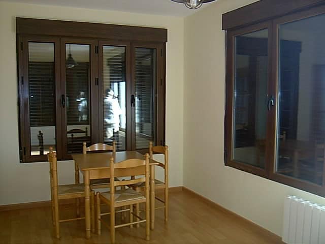 Cozy dining area with large windows in a rural finca in Huescar, Granada, offering natural light and.