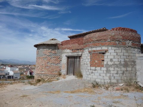 Traditional village house in Pozo Alcon, Jaen, with rustic brick walls and a scenic rural setting.