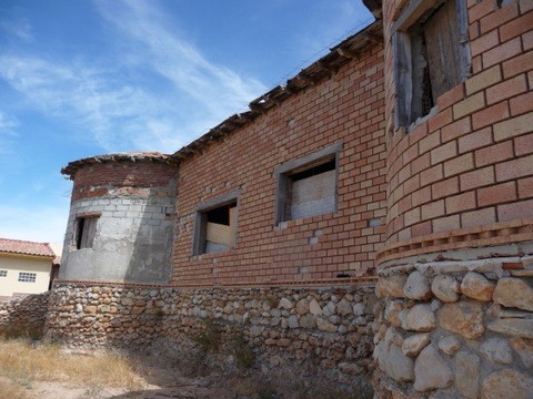Traditional village house in Pozo Alcon, Jaen with brick walls and stone foundation.