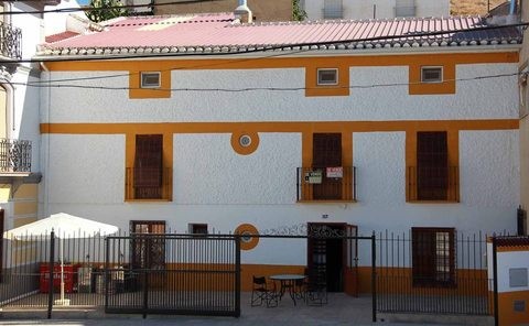 Traditional village house with white walls and orange accents in Cuevas del Campo, Granada.