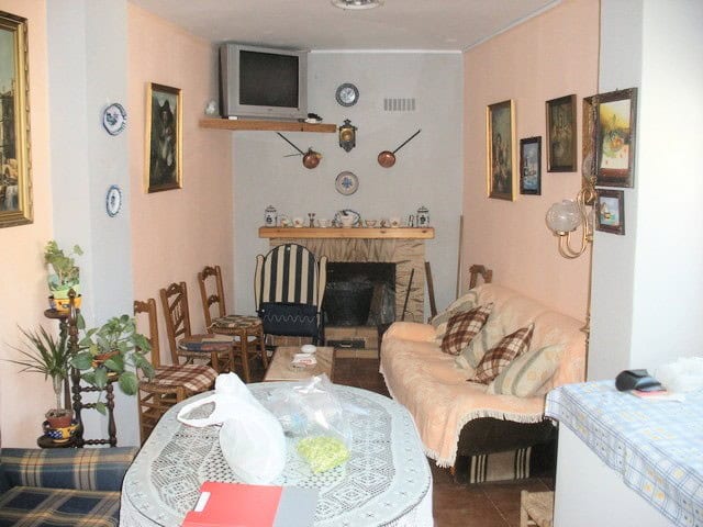 Charming cave house interior in Benamaurel, Granada, featuring a fireplace, artwork, and comfortable.