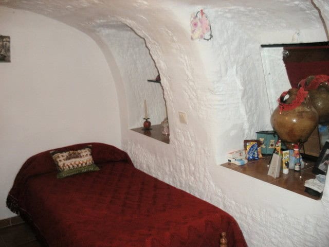 Cozy interior of a cave house with whitewashed walls and rustic decor in Benamaurel, Granada.