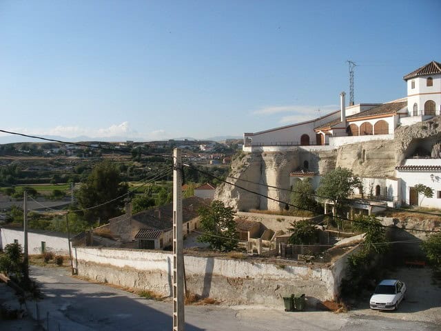 Cave house nestled in Benamaurel, Granada, with traditional white exterior and scenic hillside views.