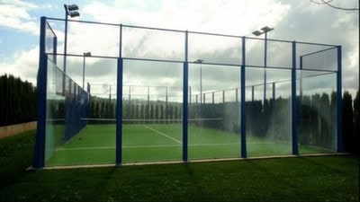 Sports court with glass walls at Pozo Alcon estate, Jaen, ideal for tennis or paddle sports.