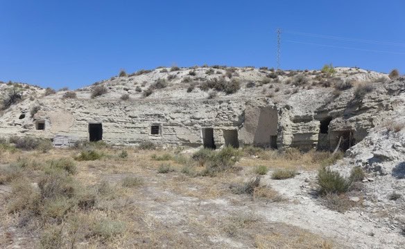 Ruins of an old structure in Benamaurel, Granada under a clear blue sky.