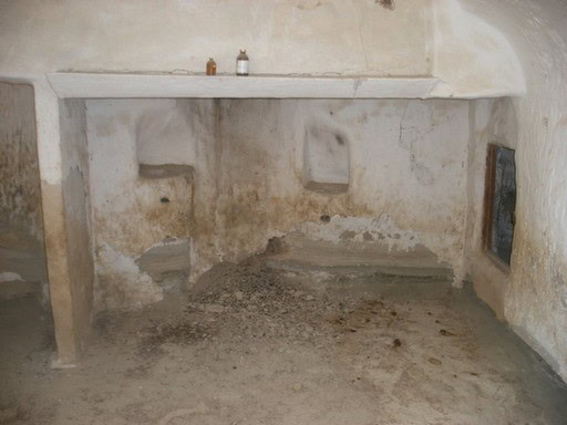 Old ruin structure in Benamaurel, Granada, showing weathered walls and dirt floor.