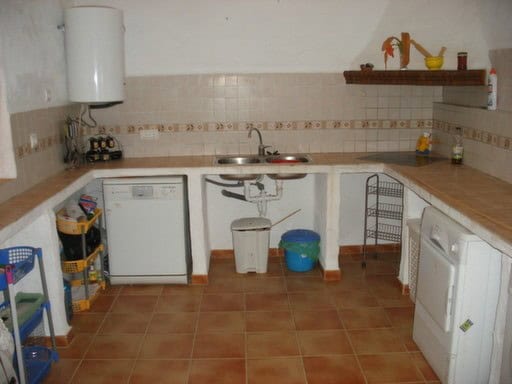 Charming village property kitchen in Gorafe, Granada, featuring basic appliances and rustic decor.