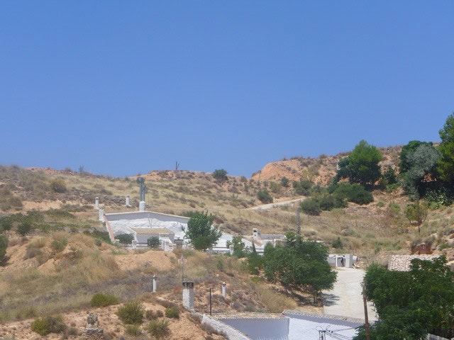 Cave house nestled in the hills of Hinojares, Jaen, with scenic views and traditional architecture.