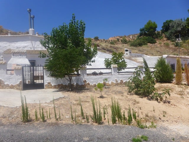 Charming cave house in Hinojares, Jaen, surrounded by natural landscape and greenery.