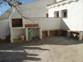 Cave house exterior in Hinojares, Jaen, with outdoor kitchen and seating area.