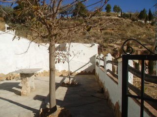 Traditional cave house exterior in Hinojares, Jaen, with rustic stone features and scenic mountain v.