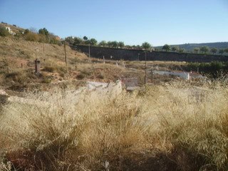 Cave house nestled in the hills of Hinojares, Jaen, surrounded by natural landscape and dry grass.