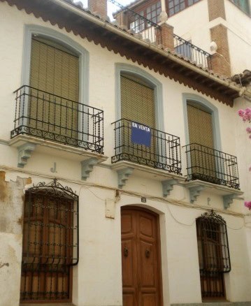 Charming village property in Guadix, Granada with traditional balconies and wooden door. Perfect for.