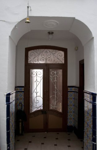 Traditional village house entrance with ornate metal gate and tiled walls in Guadix, Granada.