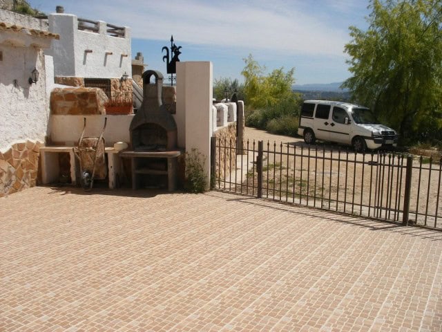 Cave house in Cuevas del Campo, Granada with outdoor oven and scenic landscape view.