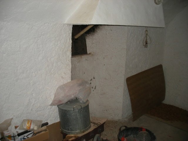 Charming cave house interior in Castillejar, Granada, showcasing rustic walls and simple furnishings.