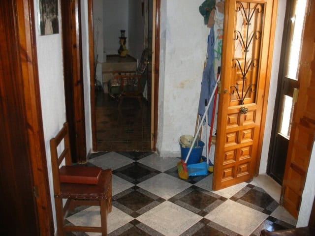 Interior view of a traditional village home in Freila, Granada, showcasing wooden doors and tiled fl.